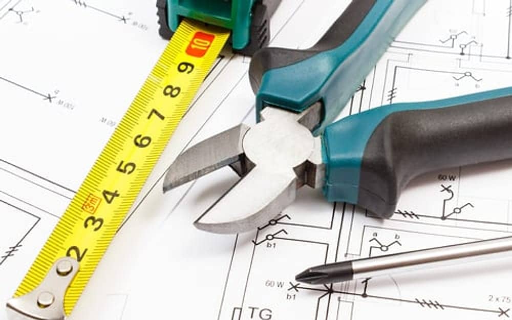 Home maintenance planning with blueprints, measuring tape and hand tools